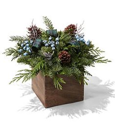 a wooden vase filled with blue flowers and greenery