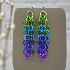 A smaller version of the Long Mesh - Peacock earrings. These earrings are bright and bold, featuring an amazingly vivid ombre from chartreuse to violet. very lightweight - each earring weighs approximately 2.4 g (about the weight of a US dime) approximately 3" long aluminum links on minimalist stainless steel earwire PEACOCK ombre: chartreuse, green, turquoise, blue, purple, violet Message me to request other colors in the Medium Mesh style. Vibrant Rainbow Dangle Earrings, Rainbow Metal Earrings With Ear Wire, Vibrant Rainbow Drop Earrings, Rainbow Metal Earrings, Rainbow Dangle Metal Earrings, Rainbow Metal Drop Earrings, Vibrant Green Dangle Earrings, Peacock Colors, Peacock Earrings