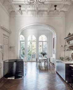 a large open kitchen and dining room with an arched doorway leading into the living room