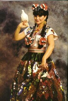 a woman in a colorful dress holding a bird