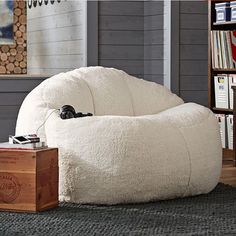 a large white bean bag chair sitting in front of a book shelf