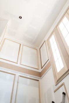 an empty room with white walls and beige trim on the ceiling is pictured in this image