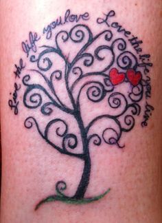 a tattoo on the leg of a woman with a tree and hearts in it that says,