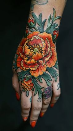 a woman's hand with an orange flower tattooed on the left side of her arm