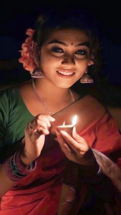 a woman holding a lit candle in her hands