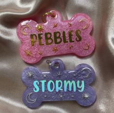 two dog tags that say pebbles and stormy on the front, one with a bone