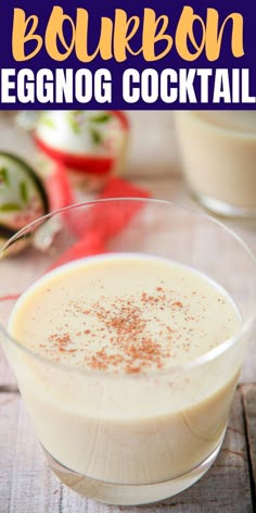 a glass filled with eggnog cocktail sitting on top of a wooden table