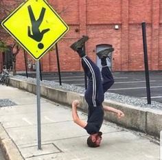 a man doing a handstand on the sidewalk next to a sign that says, when the sign god gave you doesn't seem to make sense but you still follow