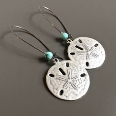 "Silver Sand Dollar Earrings - Antiqued Silver Sand Dollar accented with a small glass Turquoise bead on the earwires. The Sand Dollar is approximately 23mm (slightly smaller than US quarter). Silver plated Earwires Earrings measure just over 2.25\" from top of earwire to bottom of sand dollar More sand dollar jewelry can be found here: https://www.etsy.com/shop/mcstoneworks?search_query=sand+dollar" Adjustable Jewelry With Matching Earrings For Vacation, Adjustable Matching Earrings For Vacation, Beach Jewelry With Matching Earrings In Silver, Nickel-free Round Earrings For Beach, Silver Dangle Earrings For Vacation, Nickel Free Silver Jewelry For Vacation, Nickel-free Silver Jewelry For Vacation, Nickel-free Silver Earrings For Vacation, Silver Ear Wire Earrings For Beach