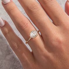 a woman's hand with a ring on it and a diamond in the middle