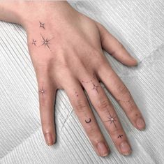 a person's hand with stars and moon tattoos on it