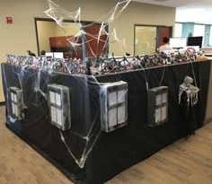 an office decorated for halloween with spider webs on the roof and windows in front of it