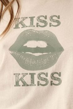 Garment washed graphic t-shirt. Vintage-style lips graphic print with "Kiss Kiss" text. Round neckline. Short sleeves. Lettuce-edge cuffs and hem. Cropped length. Relaxed fit. 100% Cotton. Imported top designed and printed in LA. Model wears size S.