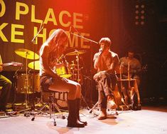 a group of people that are on stage with guitars and drums in front of them