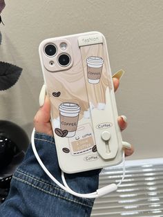 someone is holding up their phone case with coffee images on it and earphones attached to the back