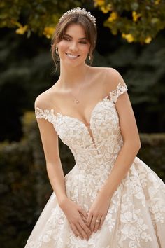 a woman in a wedding dress posing for the camera with her hands on her hips