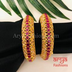 Golden Ruby Pink Polki Kada, Pair of 2 Bangles Features: Made in brass with Polki stones and Ruby pink kemp stones 22 Karat Gold finish Pair of 2 Bangles Thickness: Approx. 0.85 Inches Available in size 2.6,2.8 Openable Bangles Can fit one size up due to openable feature Screw based opening Polki Kada, Gold Finish, Screw, Ruby, Bangles, Size 2, Brass, Stone, Pink