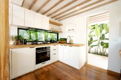 a kitchen with wooden floors and white cabinets