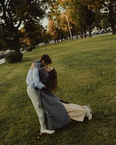 a man and woman are kissing in the grass