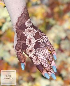 a woman's hand with henna on it and flowers painted on the palm