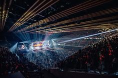 a large group of people at a concert with lights on the stage and in front of them