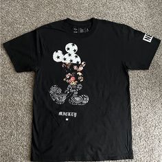 a t - shirt with an image of mickey mouse on the front and flowers on the back