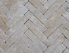 a close up view of a herringle pattern on a tile floor in grey tones