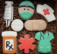 decorated cookies in the shape of doctors and nurse's items are arranged in a box