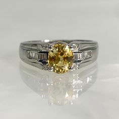 yellow sapphire, yellow sapphire ring, yellow stone, yellow sapphire diamond ring, fancy diamond ring, diamond ring, diamond engagement  A delicate and classy vintage oval shaped yellow sapphire ring featuring a 1.32 center stone complemented by 0.18 of sparkling white diamonds set in 18k white gold. *Ring size: US 7 *Ring weight: 4.89 Grams *Center stone dimensions: 6.6X5.6mm Ring Yellow Stone, Yellow Stone Rings, Yellow Sapphire Ring, Fancy Diamond Ring, Yellow Sapphire Rings, Classy Vintage, Sapphire Diamond Ring, Fancy Diamonds, Yellow Stone