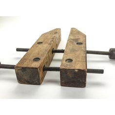 two pieces of wood sitting next to each other on top of screws and nails