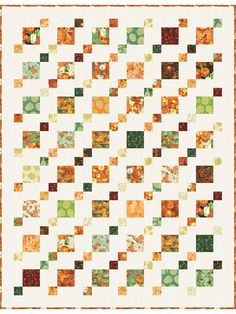 an orange and green quilt with squares in the center, on top of it is a white background