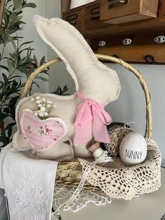 an easter bunny sitting on top of a table next to a basket with eggs in it