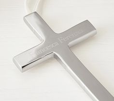 a silver cross with the word frances perrezzi written on it is laying on a white surface