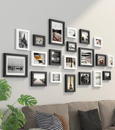 a living room filled with lots of framed pictures on the wall next to a couch