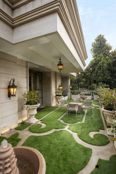 an outdoor patio with artificial grass and potted plants