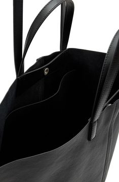 Bring it all with you—we're talking your essentials, laptop and an extra layer for unpredictable weather—with this leather tote crafted with winged gussets that enhance its carrying capacity. You can hold it in hand with the top handles or sling it over your shoulder with the longer straps when it's packed to the max. Top snap closure Top carry handles; shoulder straps Interior wall pocket Leather lining Leather Imported Allsaints Modern Leather Bags, Versatile Leather Laptop Bag For On-the-go, Allsaints Leather Bags For Everyday Use, Allsaints Leather Everyday Bag, Minimalist Leather Travel Shoulder Bag, Minimalist Leather Shoulder Bag For Travel, Versatile Leather Laptop Bag For Everyday Use, Travel Bags In Textured Faux Leather, Textured Faux Leather Travel Bags