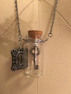 "Necklace with a key in a glass bottle and a lock charm Gunmetal chain necklace 27\" in length Glass Bottle 1.75\" in length" Lock And Key Necklace, Under Lock And Key, Astoria Ny, Glass Vials, Key Necklace, Lock And Key, Glass Bottle, Glass Bottles, Charm Necklace