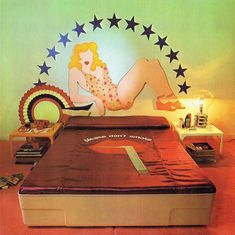 a woman laying on top of a bed in front of a wall with stars above it