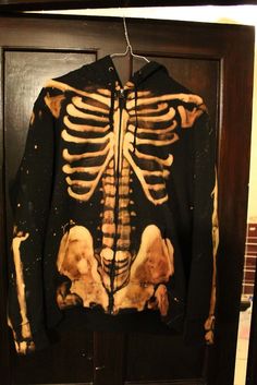 a jacket with a skeleton on it hanging from a door