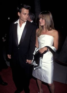 a man and woman are walking together at an event