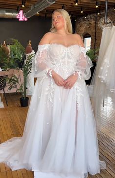 a woman in a white dress posing for the camera with her hands on her hips