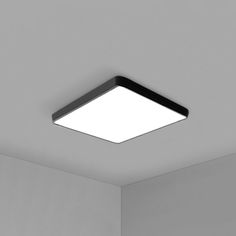 an empty room with a square light fixture on the ceiling