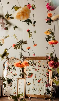 an assortment of flowers are hanging from the ceiling in front of a mirror and other decorations