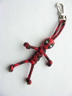 a red and black spiderman key chain on a white surface