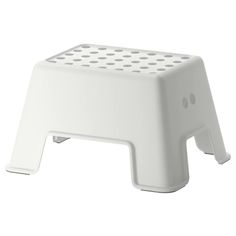 a white step stool with holes on it