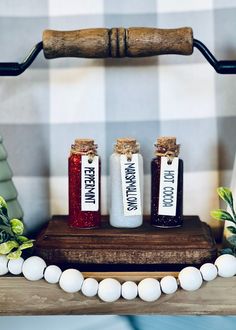 three small bottles with labels on them sitting on a wooden board next to some eggs