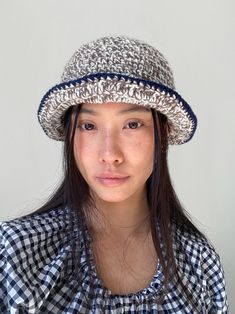 a young woman wearing a hat and looking at the camera