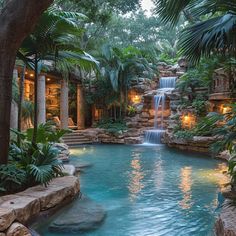 an outdoor swimming pool with waterfall surrounded by greenery