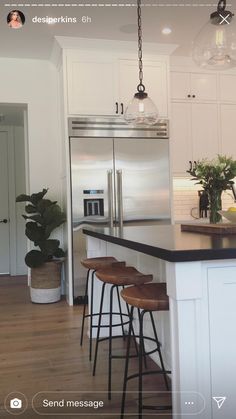 a kitchen with two stools next to a counter top and an island in the middle