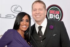 a man and woman posing for a photo on the red carpet at an awards event